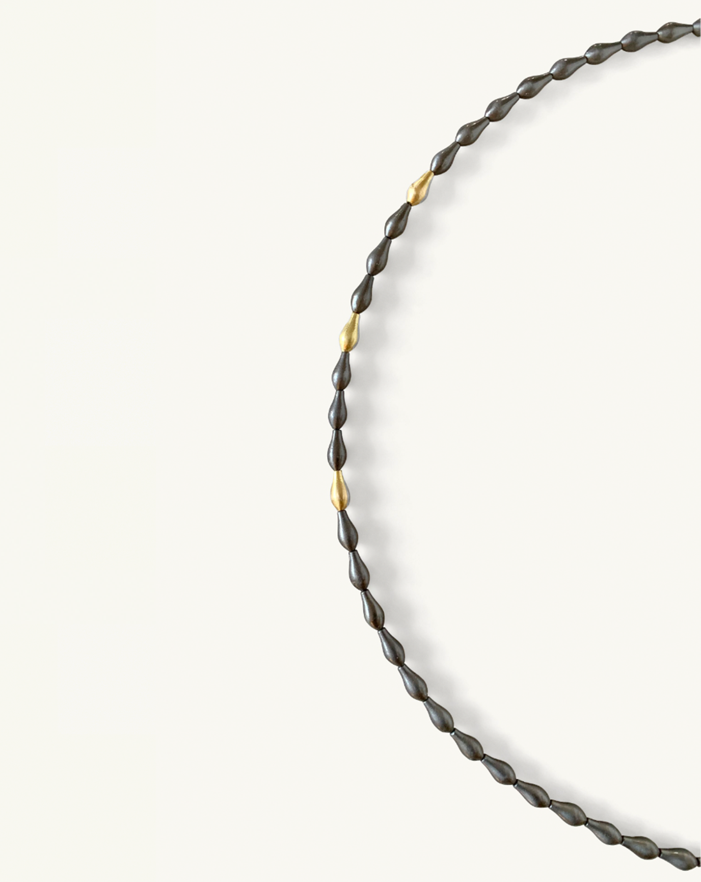 Close up product image of the pod necklace with grey pod beads with a few gold beads included