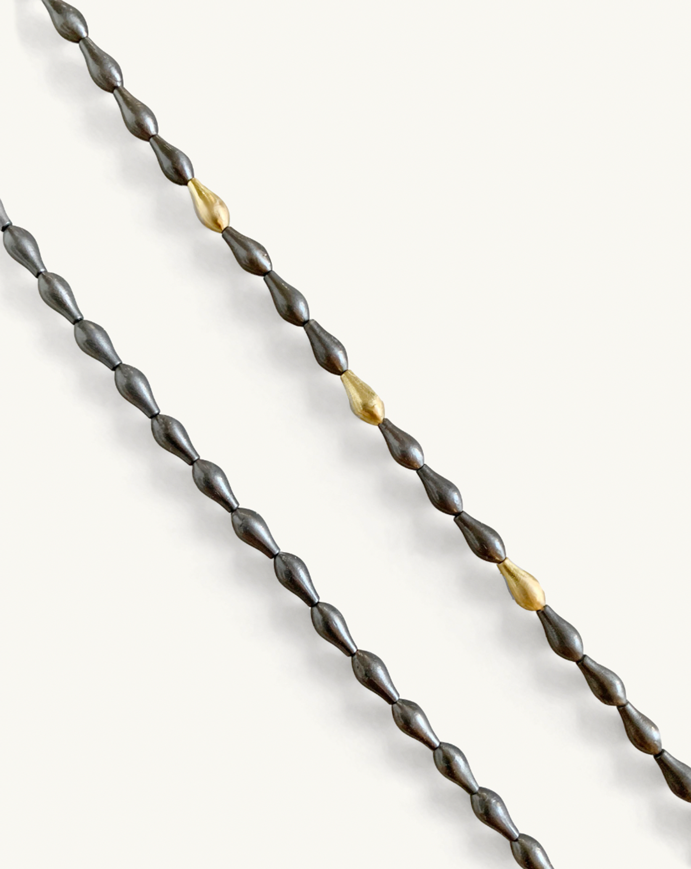 Close up product image of the pod necklace with grey pod beads with a few gold beads included