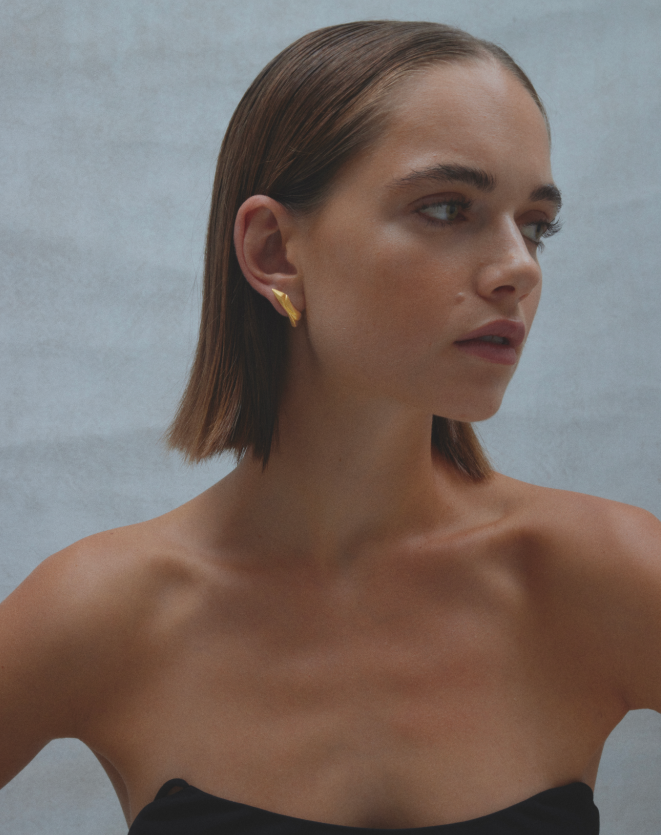 i seira model, wearing the sculptural climber earrings with her head slightly turned