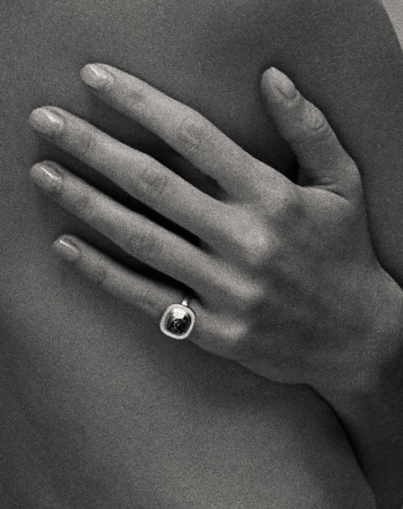 Black and white close up image of the statement ring on the pinky finger of the model