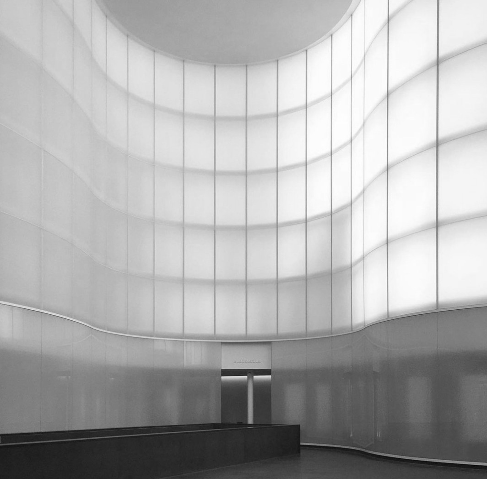 Black and white image of a opaque glass wall in a museum
