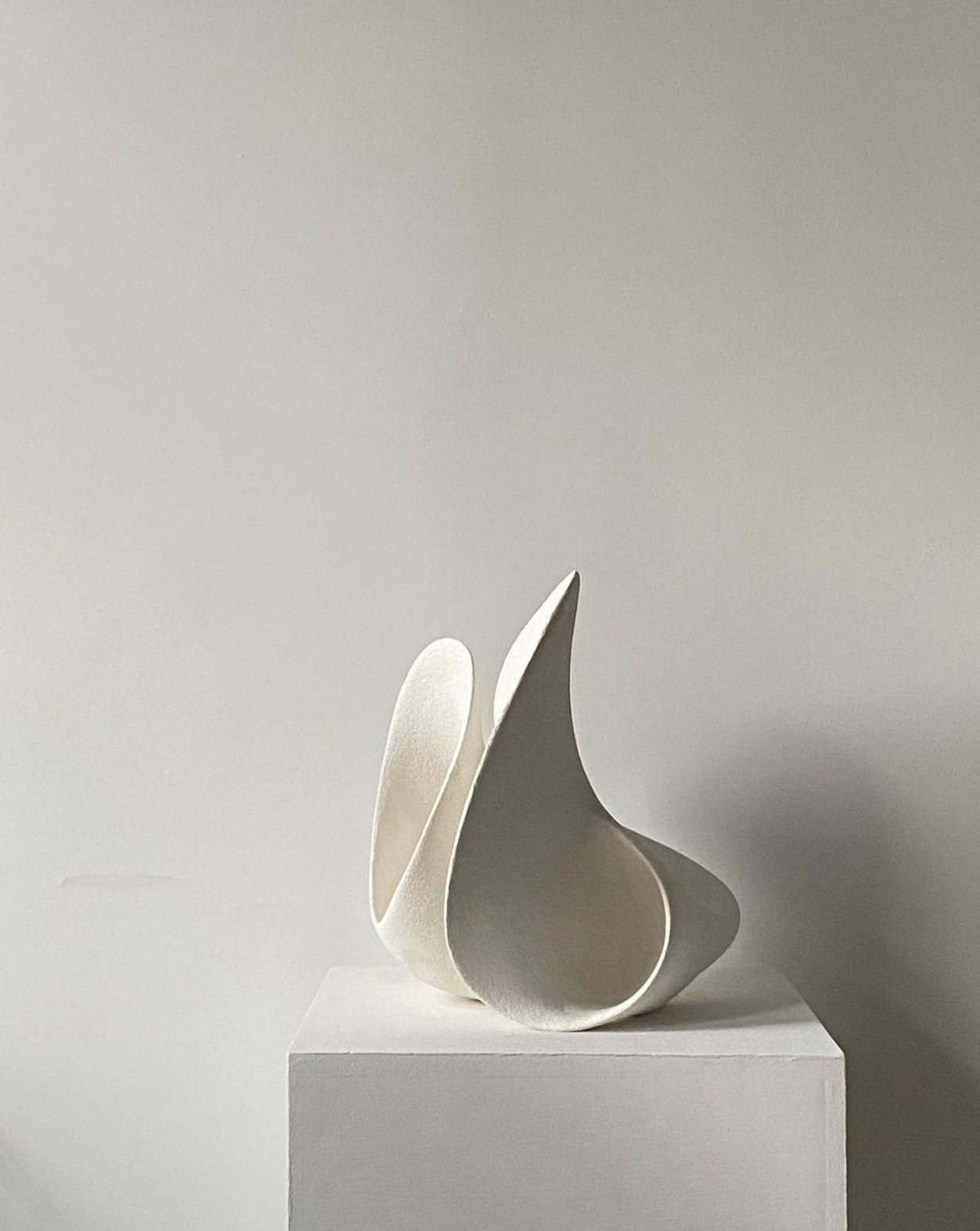 Clay sculpture on a white block in front of a white wall