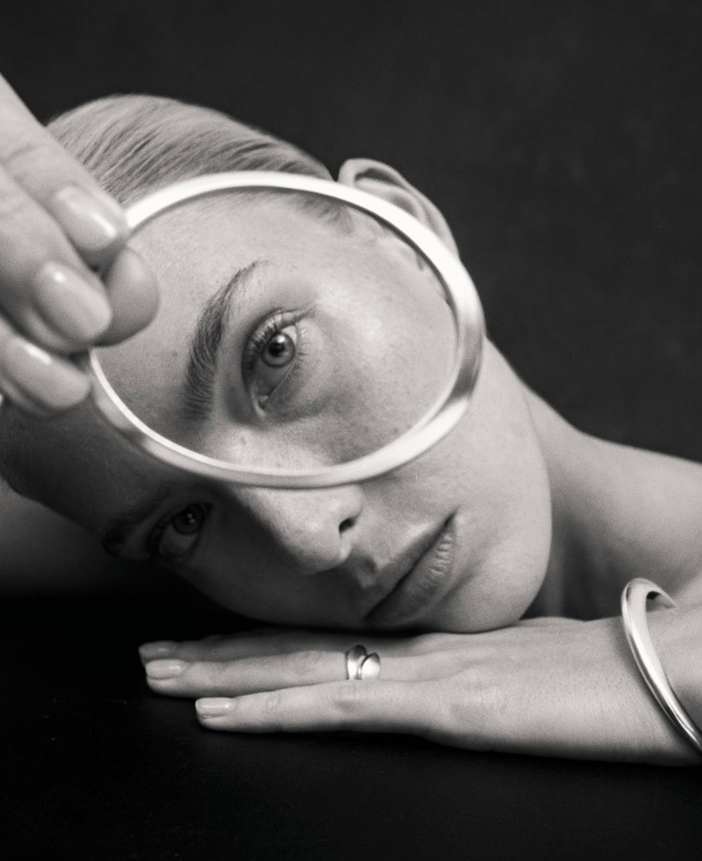 black and white image of i seira model looking through the oval bangle