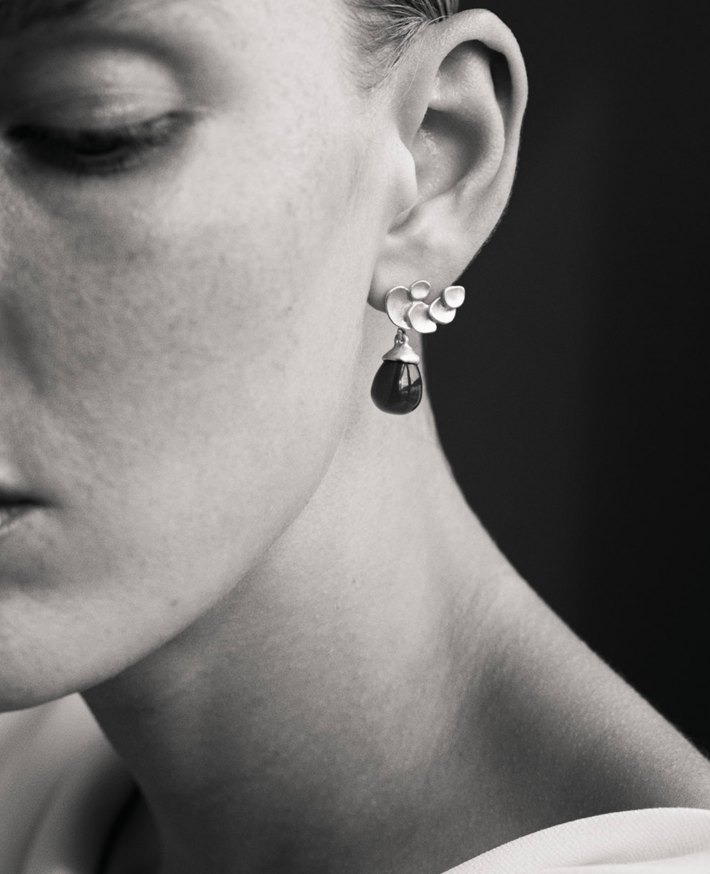 black and white image of i seira model wearing the gemstone drop earrings in grey moonstone