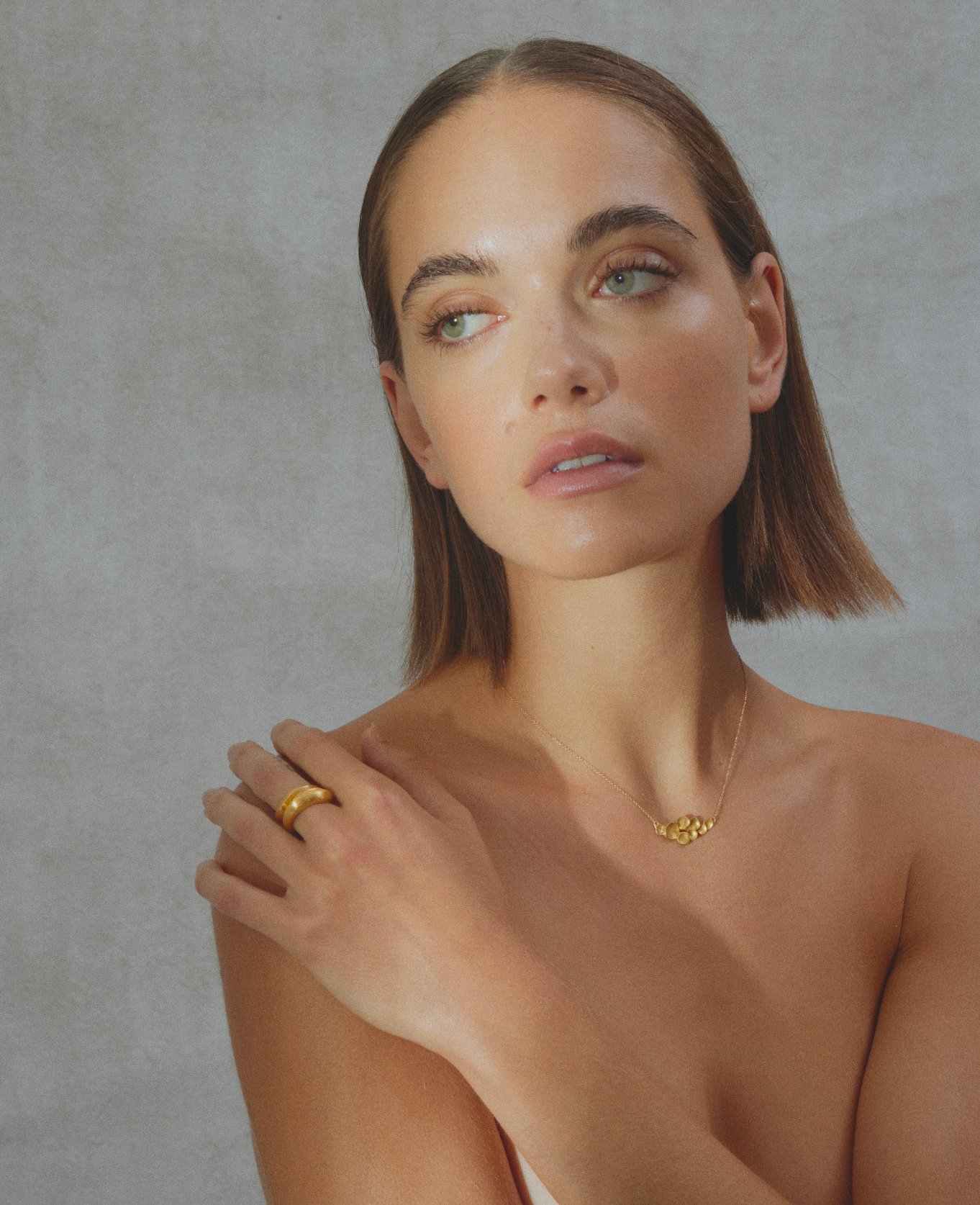 i seira model wearing nothing but the abstract pendant necklace paired with the sculptural ring