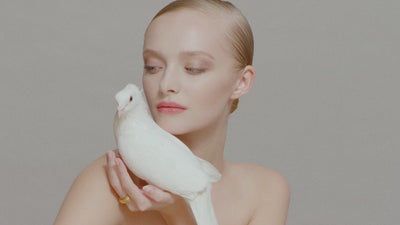 i seira models present gold sculptural jewelry and interact with a snake and a dove in an artistic format.